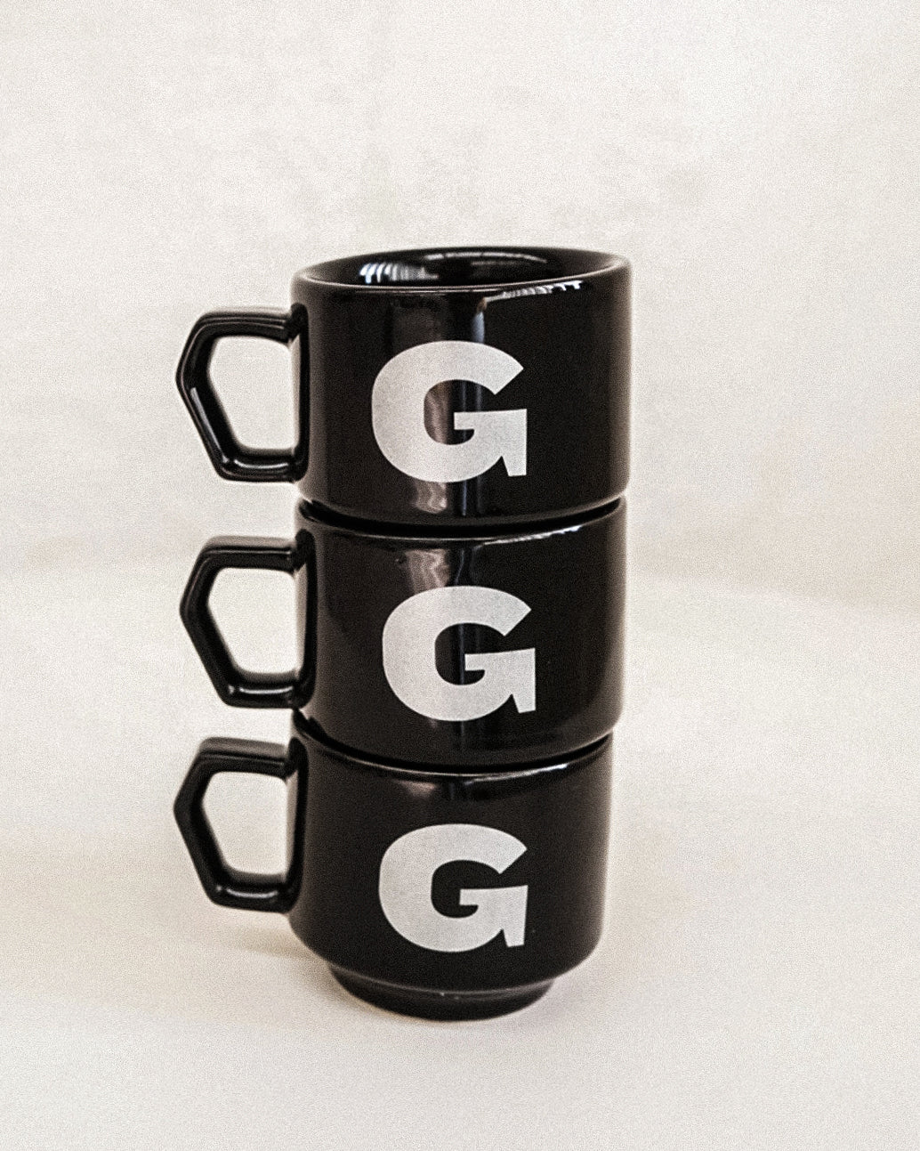 3 stacked 90ml espresso cups in black with large silver G print